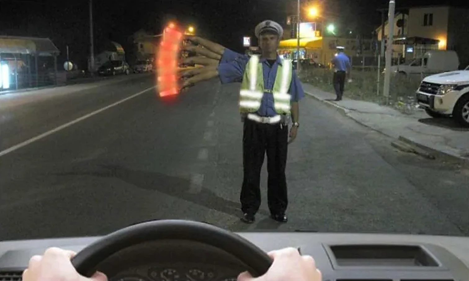 U situaciji prikazanoj na slici, kada policijski službenik daje svetlosni znak baterijskom lampom koja emituje postojano crveno svetlo mašući upravno na uzdužnu osu puta, dužni ste da: