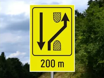označava blizinu mesta gde se dvosmerni saobraćaj sa dela puta na kojem kolovozne trake nisu fizički razdvojene, odnosno razdvojene su oznakama na kolovozu, preusmerava na deo puta na kojem su kolovozne trake fizički razdvojene